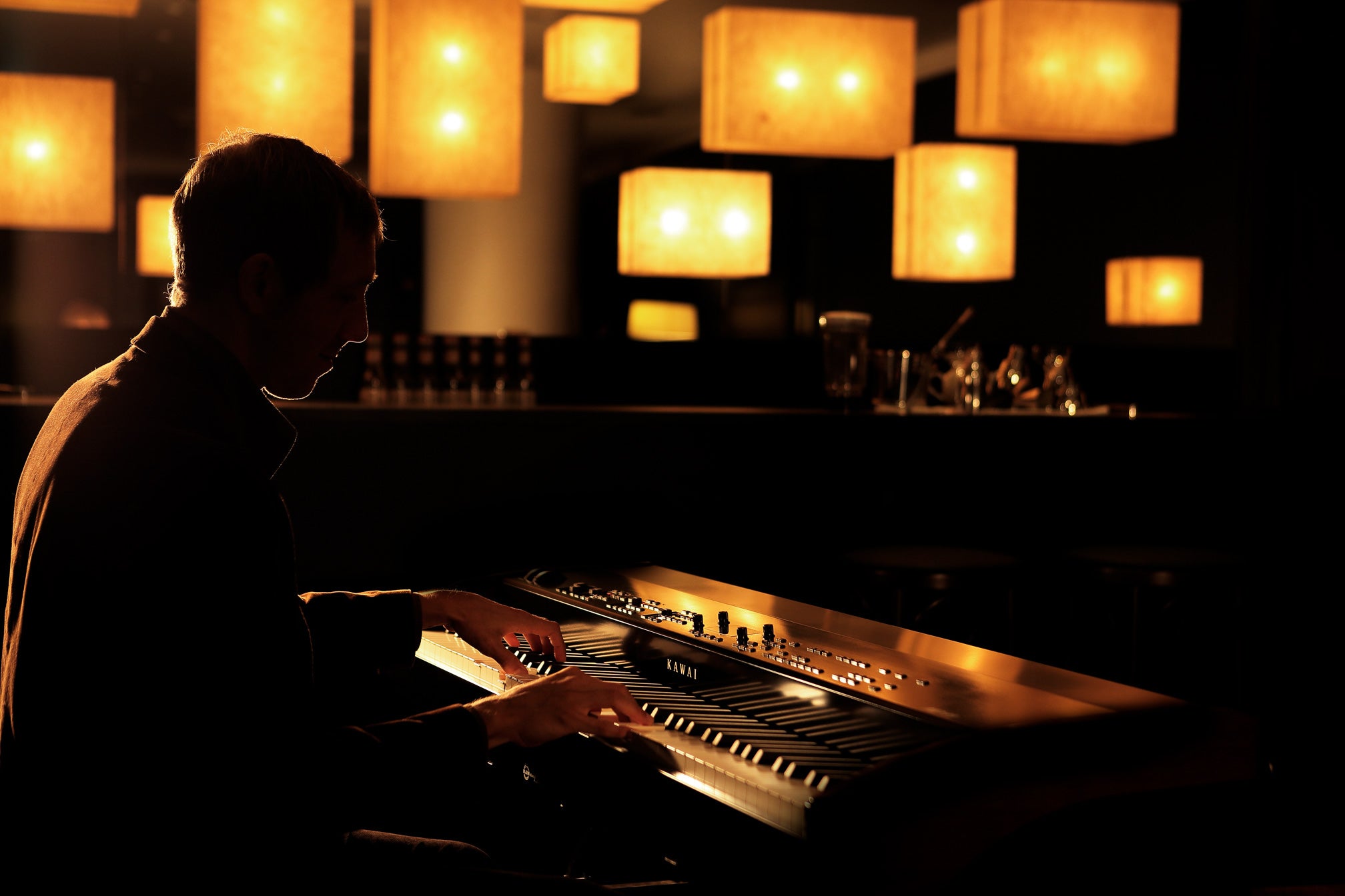 James plays the Kawai MP11SE in a dimly lit bar