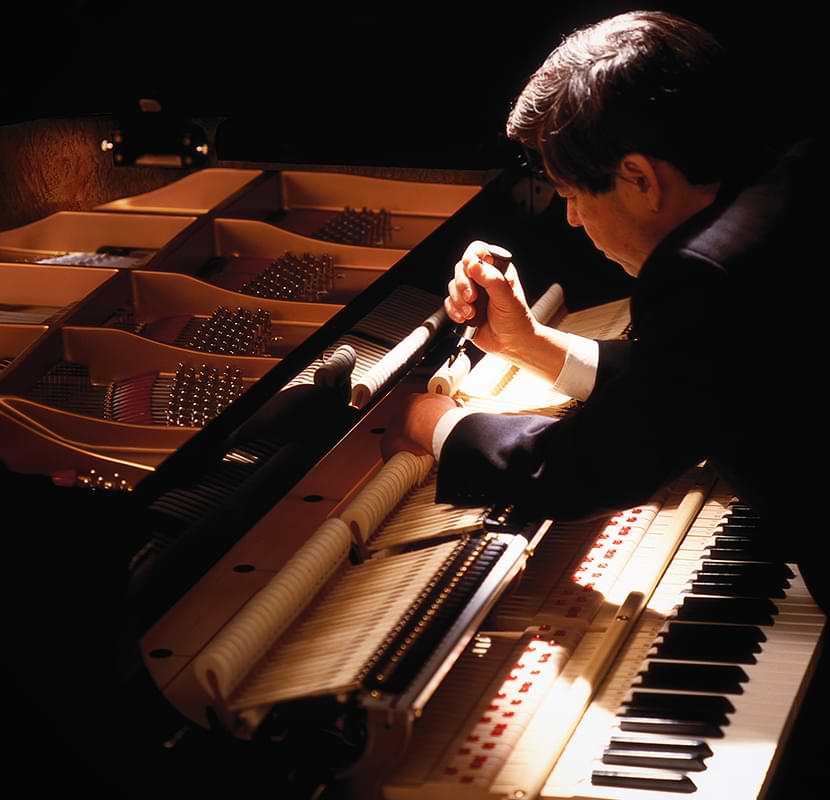 Piano technician working on a grand piano